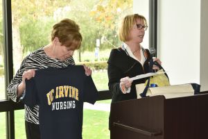 uci retiree maureen zehtner gives t-shirt to author robyn carr