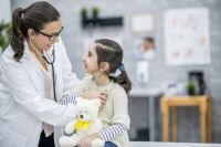 pediatric cancer patient being examined by a nurse; uci school of nursing associate professor michelle fortier leads four studies on pediatric cancer