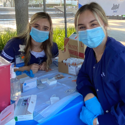 UC Irvine school of nursing students Haley Kurz (left) and Julia Cowell and flu vaccine popup