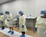 High school students donning isolation gowns at Nursing Camp in Summer at the UC Irvine Sue $ Bill Gross School of Nursing.