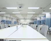 Hospital Bed Unit with high white tables and hospital beds flanking both sides in the UC Irvine Sue & Bill Gross SIM Center