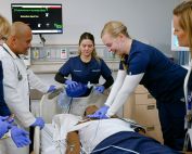 Students and faculty performing a code simulation in the ICU simulation suite at the UC Irvine Sue & Bill Gross SIM Center