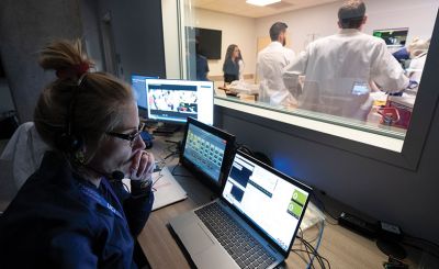 Jocelyn Ludlow in dimmed lighting watching simulation from the SIM Control Room